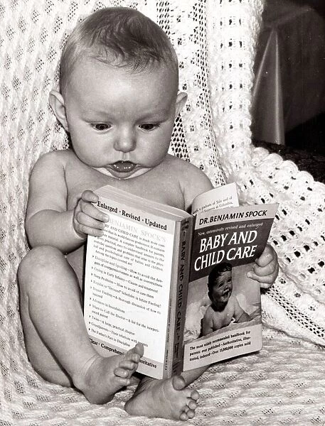 Baby reading up on how his parents should raise him. Circa 1950