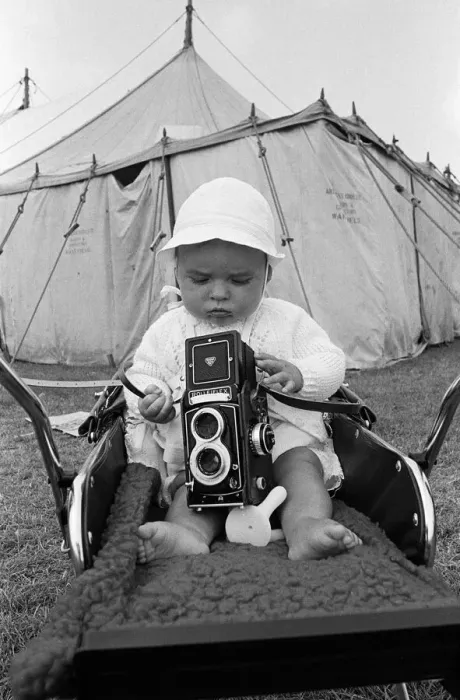 Framed Print : A baby sitting with a Rolleiflex camera at Skelton annual baby show. Circa 1973