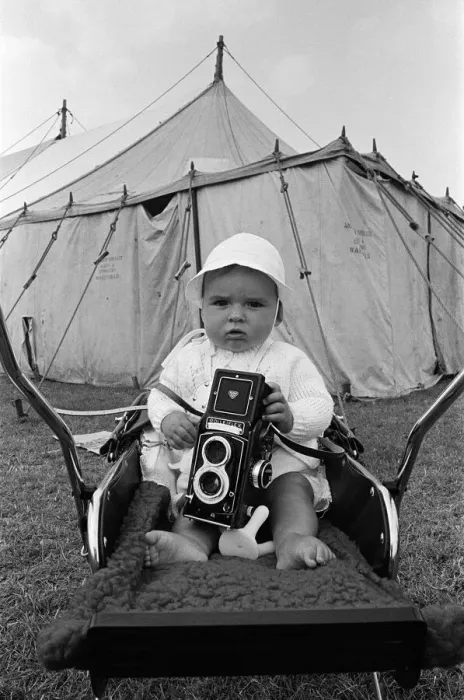 Framed Print : A baby sitting with a Rolleiflex camera at Skelton annual baby show. Circa 1973