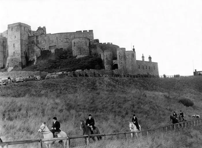 Framed Print : Bamburgh Castle made an impressive background as followers of the Percy Foxhounds moved