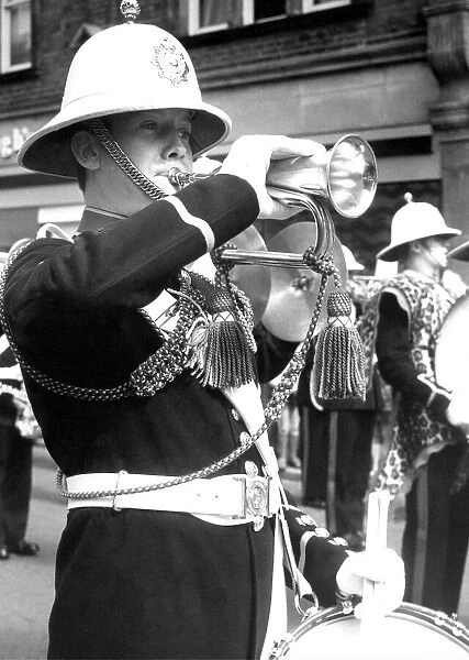A bandsman playing the bugle and snare drum in July 1977