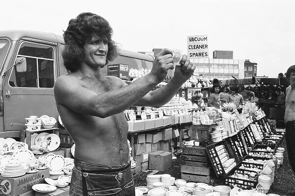 Bare chested Alan Dobbs who runs a pottery stall in London