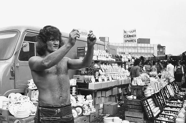 Bare chested Alan Dobbs who runs a pottery stall in London