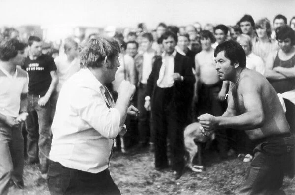 Bare - knuckle boxing on The Berkshire Downs. A large crowd surrounds two fighters for