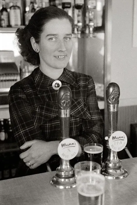 Framed Print : The barmaid at The Chimes Lansbury Public House stands behind the bar beside the beer Framed Print : The barmaid at The Chimes Lansbury Public House stands behind the bar beside the beer