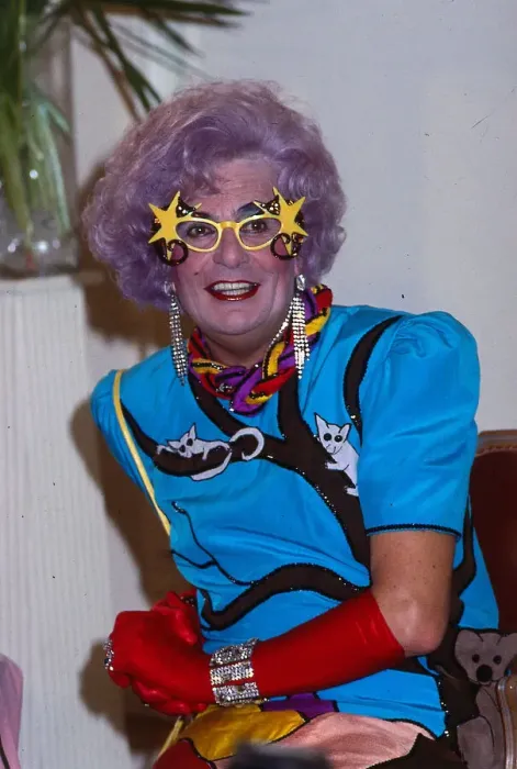 Framed Print : Barry Humphries as Dame Edna Everage wearing blue dress red gloves Framed Print : Barry Humphries as Dame Edna Everage wearing blue dress red gloves