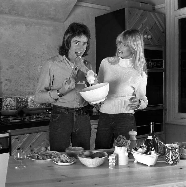 Barry Sheene with girlfriend Stephanie McClean at home in kitchen making food