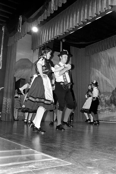 Bavarian couples in traditional dress dancing on stage during a night out in Ruhpolding