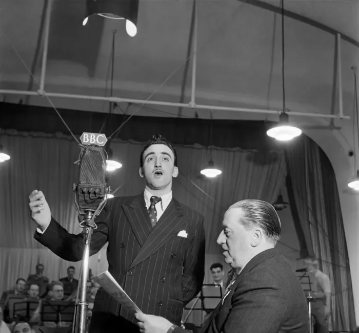 Framed Print : BBC Producer Leslie Bridgemont holds the songsheet for the Singing Waiter as he sings