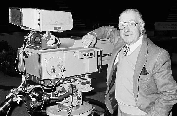 BBC snooker commentator Ted Lowe standing beside a television camera