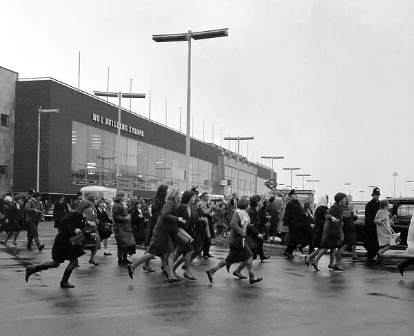 The Beatles arrive at London airport from Sweden. Fans running across the airport to