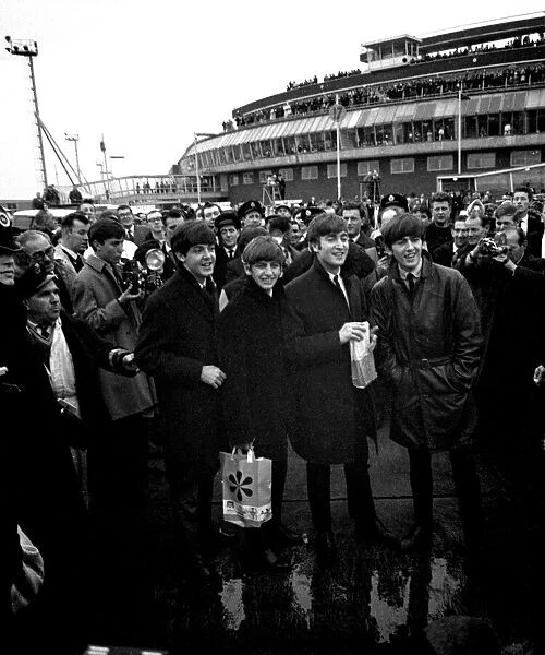 The Beatles arrive at London airport from Sweden. Surrounded by police, press and fans
