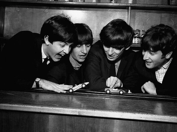 The Beatles in Coventry, amusing themselves with a miniture car race track before their