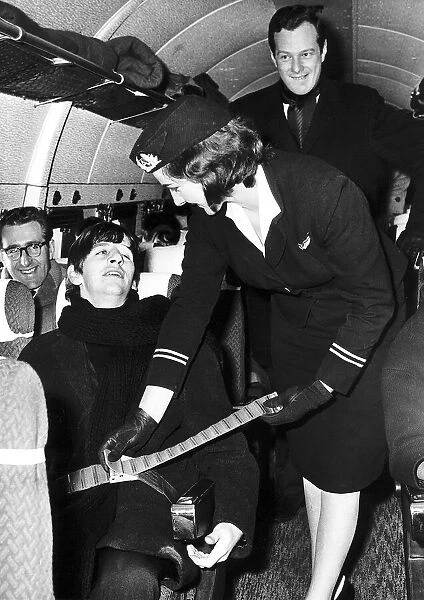 Beatles drummer Ringo Starr has his seat belt fastened air stewardess Sheila Whitworth