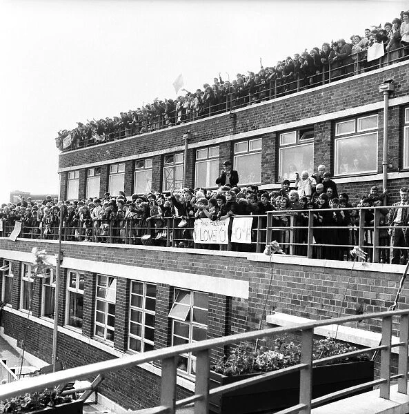 Beatles fans packed onto a building terrace and rooftop as they try to get a glimpse of