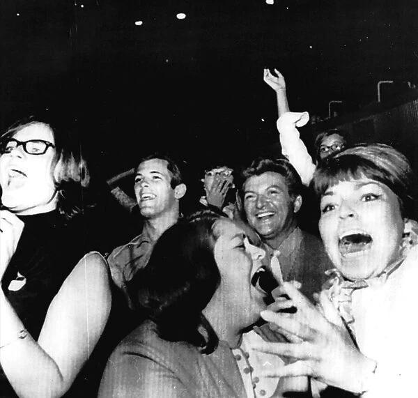 Beatles fans scream as their idols perform on stage August 1964