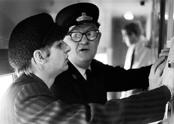 The Beatles February 1964 Ringo Starr with train conductor checking the timetable