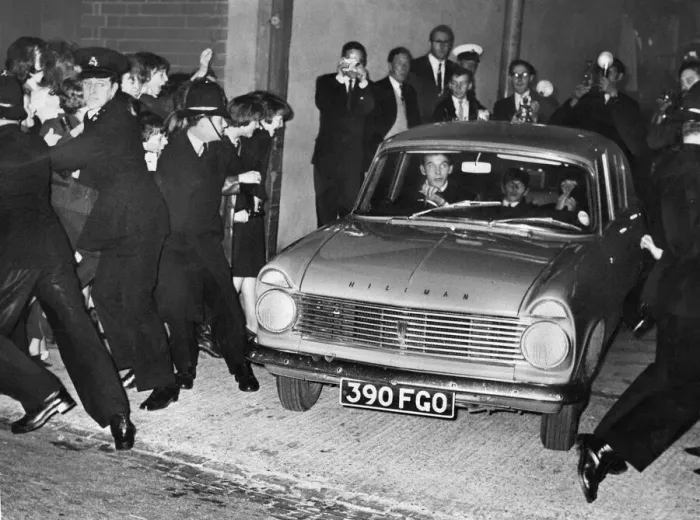 Framed Print : The Beatles in a Hillman with fans held back by the police at the Birmingham Hippodrome