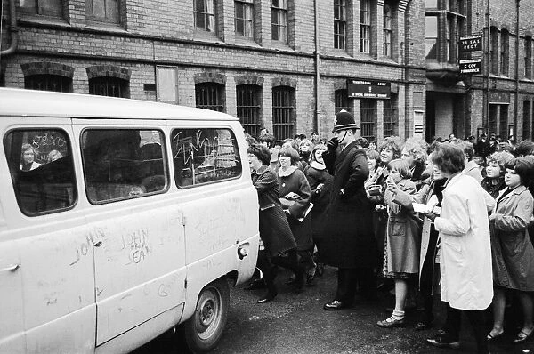 The Beatles leave Birmingham in a van surrounded by hundreds of screaming fans