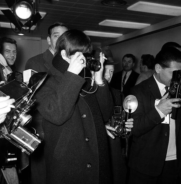 The Beatles Leaving for New York. Ringo Starr taking pictures of Paul McCartney along