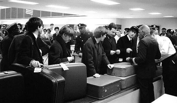 The Beatles and manger Brian Epstein waiting for their luggage after arriving in New York