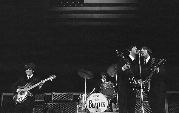 The Beatles onstage before the stars and stripes on the second night of their US tour at