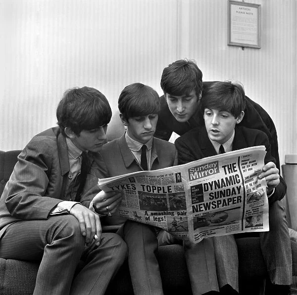 Beatles pop grouo reading the Sunday Mirror newspaper. Left to right