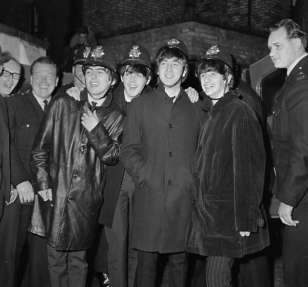 The Beatles pop group pose with a group of policemen in Birmingham