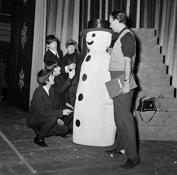 The Beatles pose with a Snowman, as they take a break from rehearsals at the Astoria