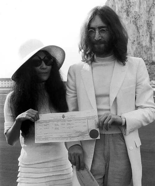Beatles singer John Lennon and his new bride Yoko Ono holding their marriage certificate