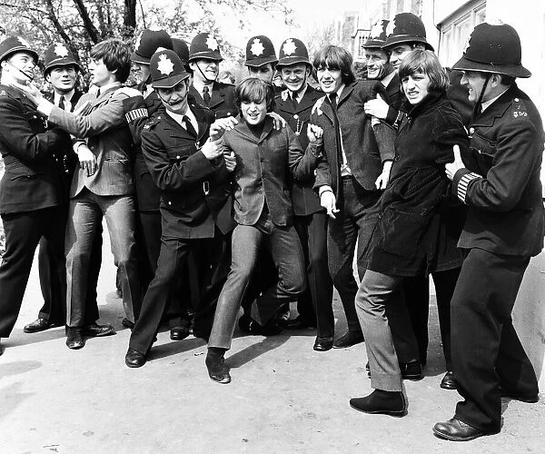 The Beatles in the strong arm of the law while filming 'Help