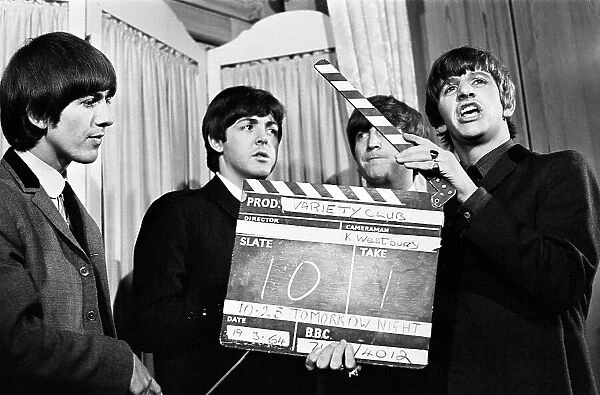 The Beatles at the Variety Club Awards, March 1964. George Harrison, Paul McCartney, John Lennon (partially hidden) and Ringo Starr fooling around with a clapperboard