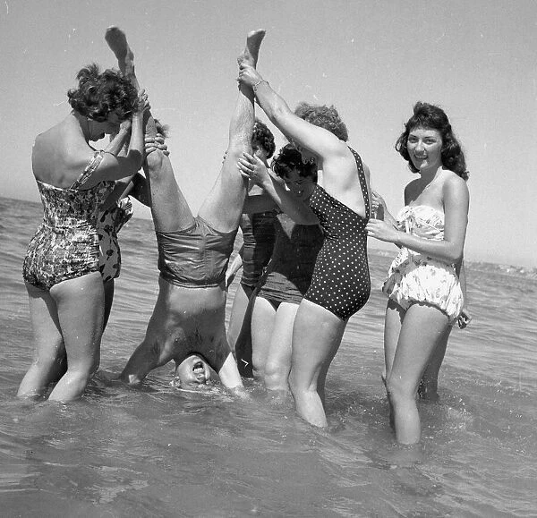 Beauty contest girls playing on the beach at Sandbanks with the compere of