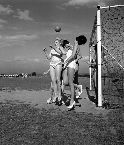 Beauty contest girls playing football at Filey. 30th August 1960