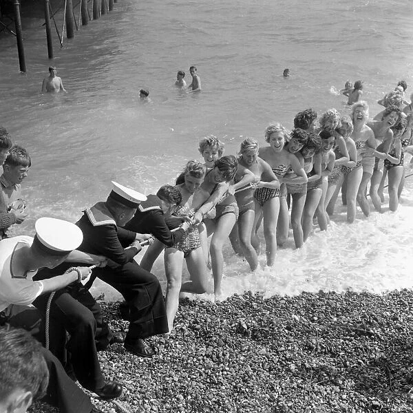 Beauty contest girls playing tug of war with a group of sailors at Southsea, UK