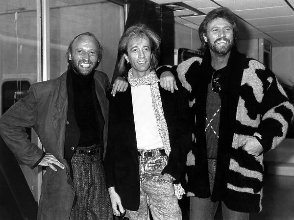The Bee Gees Pop Group leaving Heathrow for Paris. Robin Gibb flanked by his two