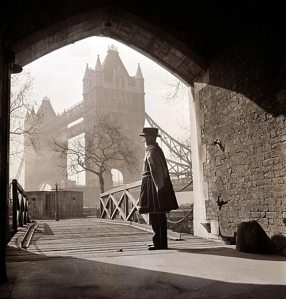 A beefeater guards the entrance to the Tower of London circa 1950s