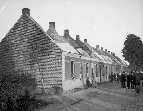 Belgian civilians view the burnt out cottages in Mella
