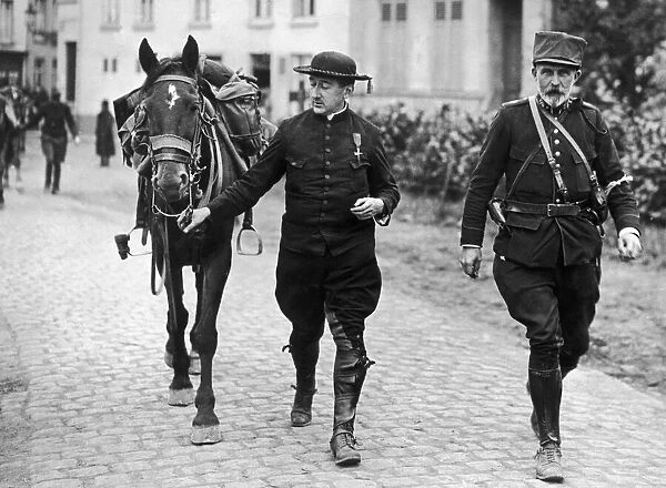 Belgian priest decorated for his bravery is seen here with a cavalry officer following
