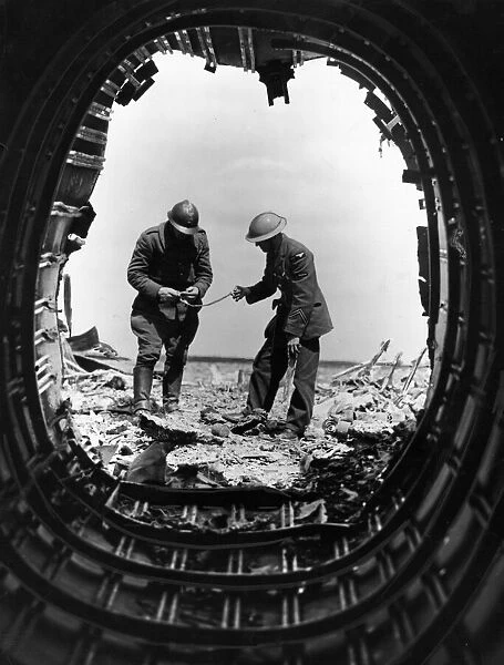 A Belgian soldier and a British airman examine the wreckage of a Heinkel bomber brought