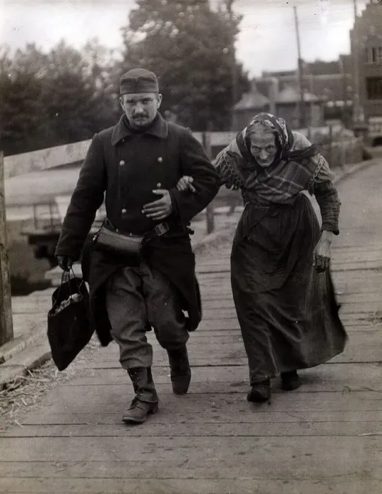 Framed Print : Belgian Soldier helps an aged woman refugee. August 1915 Framed Print : Belgian Soldier helps an aged woman refugee. August 1915