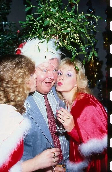 Benny Hill comedian December 1991 Being kissed under mistletoe by two girls