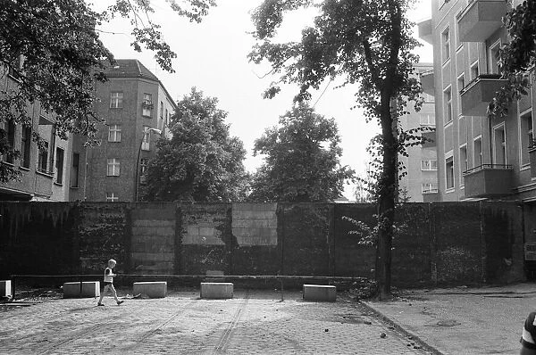 The Berlin Wall. The wall running into houses on either side of the road