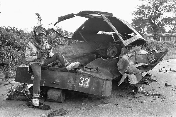 A Biafran soldier seen here sitting on a destroyed Nigerian army armoured personnel