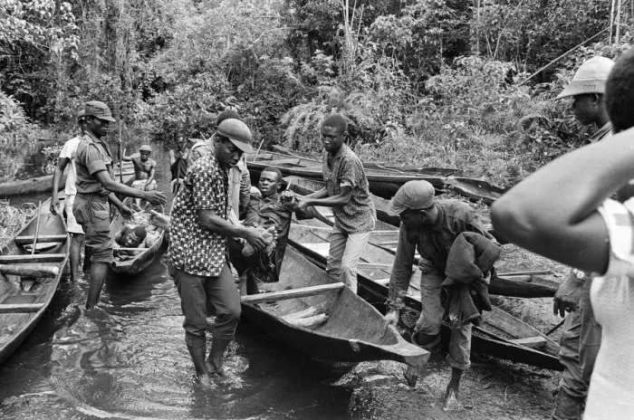 Framed Print : Biafran soldiers and helpers seen here carrying an injured comrade onto a canoe to cross Framed Print : Biafran soldiers and helpers seen here carrying an injured comrade onto a canoe to cross
