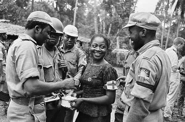 Biafran soldiers seen here enjoying some food held by an aid worker during the Biafran