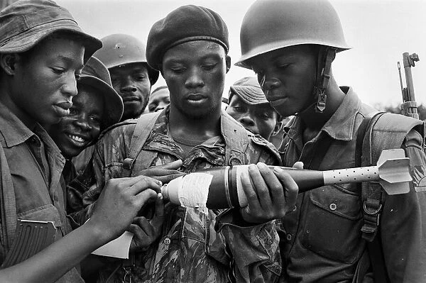 Biafran soldiers seen here inspecting a bomb during the Biafran conflict, 11th June 1968
