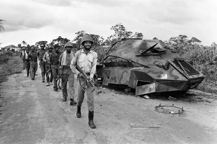 Framed Print : Biafran soldiers seen here marching past a destroyed Nigerian army armoured personnel Framed Print : Biafran soldiers seen here marching past a destroyed Nigerian army armoured personnel