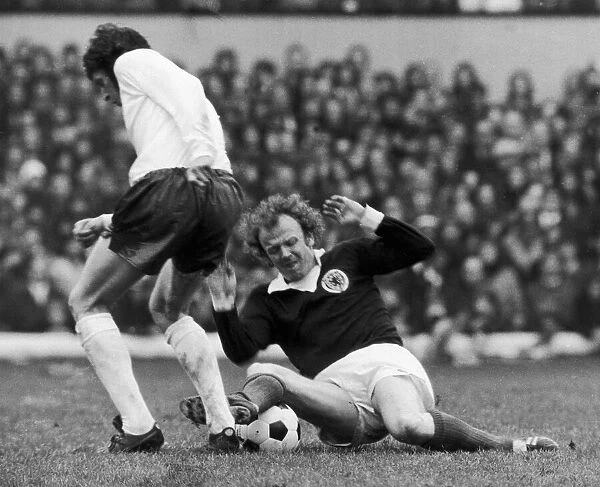Billy Bremner in action against a un-named English player during Scotland