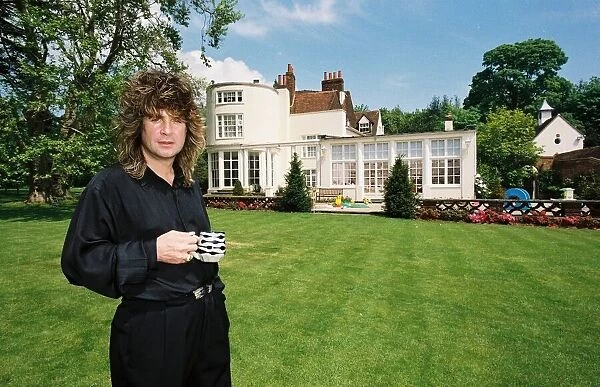 Black Sabbath singer Ozzy Osbourne holding a cup of tea in the garden of his home